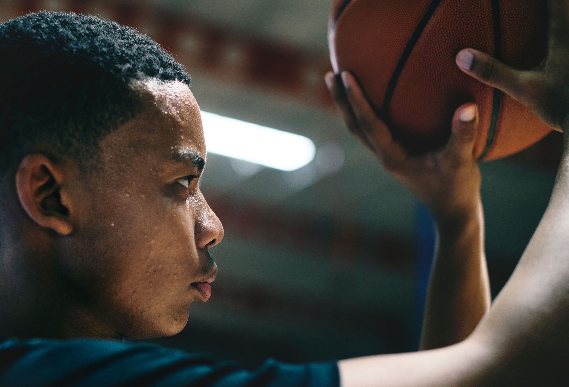 African American teenage boy concentrated on playing basketball